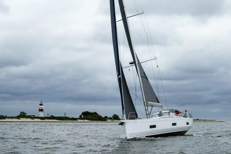 Slide: The Image of 2026 X-Yachts X4 9 sailing near a lighthouse under cloudy skies. - 3