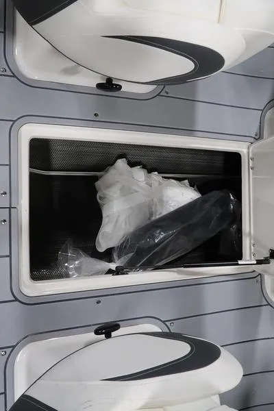 Slide: The Image of 2025 Chaparral 21 SSi boat storage compartment with items inside. - 18