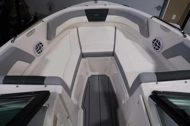 Slide: The Image of 2025 Chaparral 21 SSi boat interior with white and gray seating, speakers, and storage. - 2