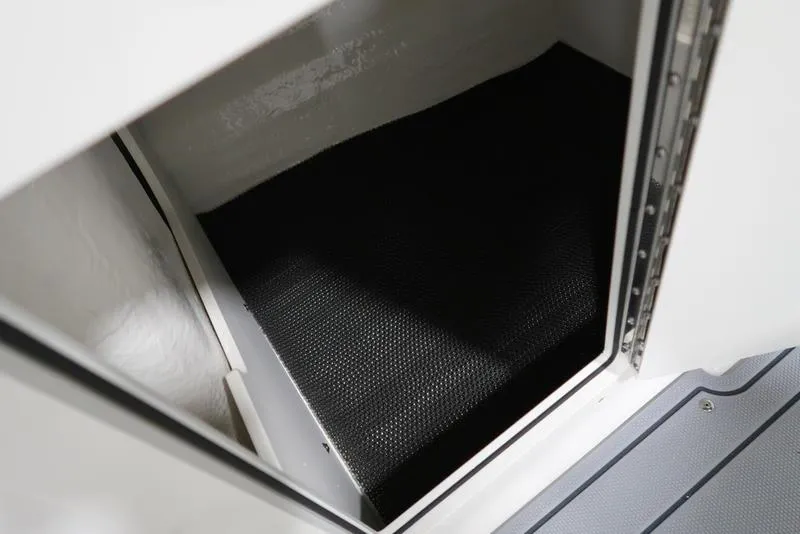 Slide: The Image of Interior storage compartment of 2025 Chaparral 21 SSi boat, featuring black flooring. - 27
