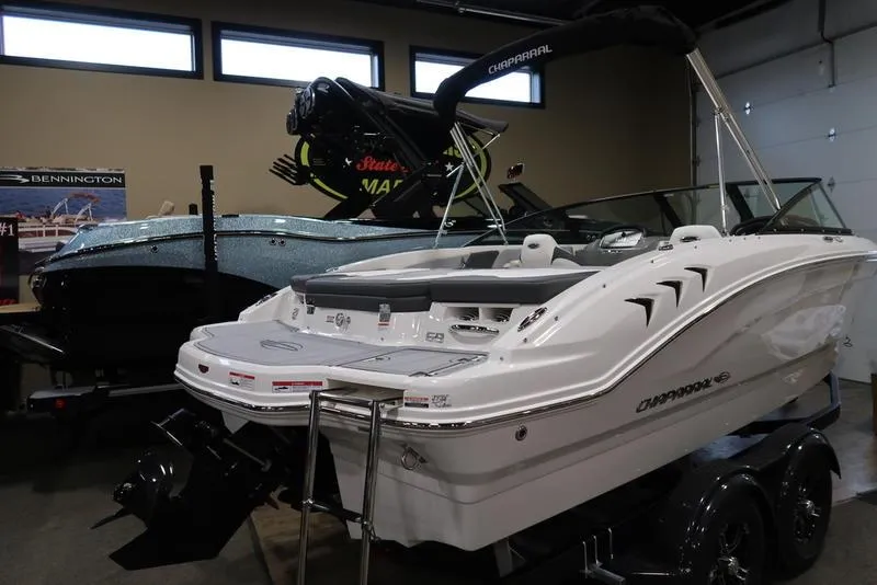 Slide: The Image of 2025 Chaparral 21 SSi boat in showroom, white exterior, on trailer. - 4