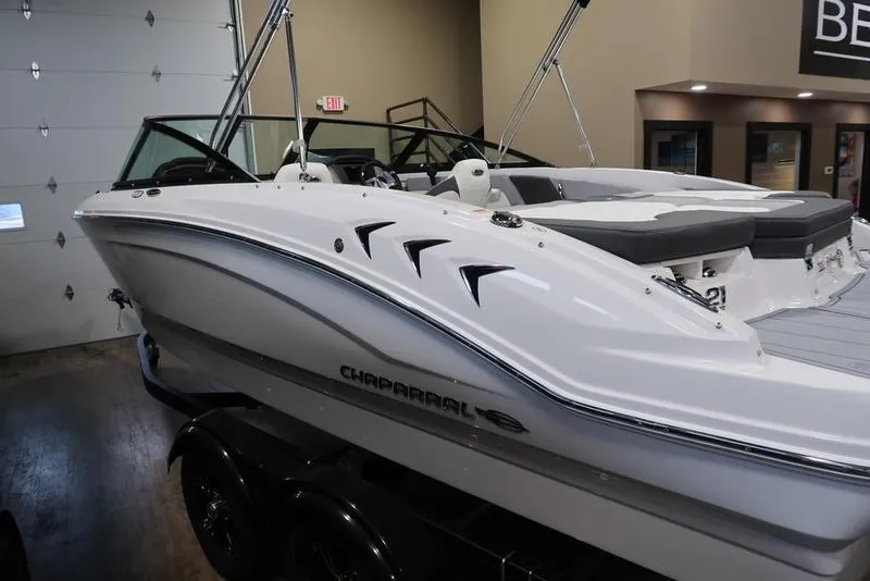 Slide: The Image of 2025 Chaparral 21 SSi boat in showroom, sleek white design, modern features. - 8