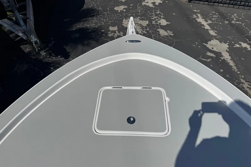 Slide: The Image of Bow of 2026 Shallow Sport 22 Sport boat with storage hatch, shadow visible. - 20
