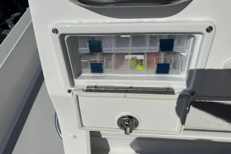 Slide: The Image of 2026 Shallow Sport 22 Sport boat tackle storage compartment with organized fishing gear. - 9