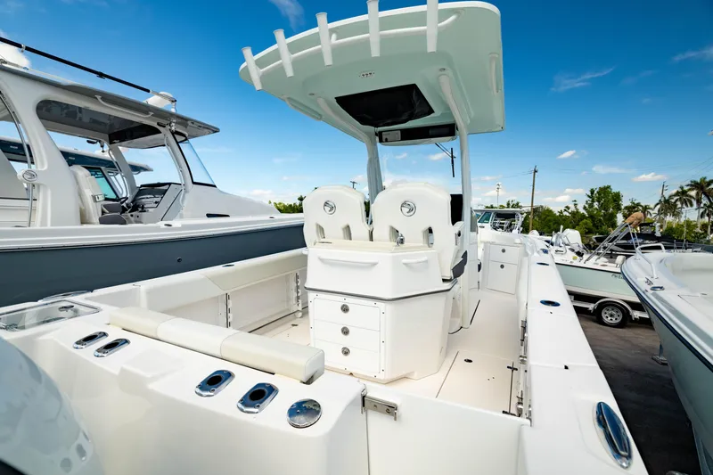 Slide: The Image of 2025 Edgewater 262CC boat with sleek design, spacious deck, and modern features under a clear blue sky. - 13