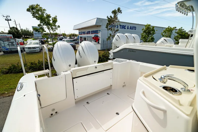 Slide: The Image of 2025 Edgewater 262CC boat with dual engines, parked near a tire and auto shop. - 15