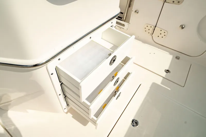 Slide: The Image of 2025 Edgewater 262CC boat storage drawers, open and organized, showcasing sleek design. - 19
