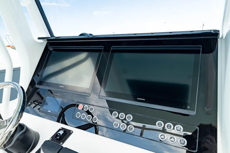 Slide: The Image of Edgewater 262CC 2025 dashboard with dual Garmin displays and control panel. - 28