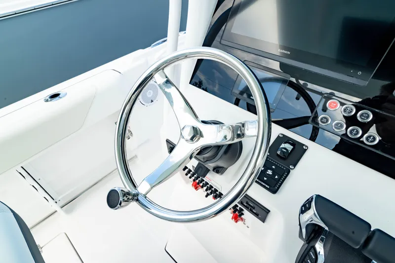Slide: The Image of 2025 Edgewater 262CC boat helm with steering wheel and control panel. - 34