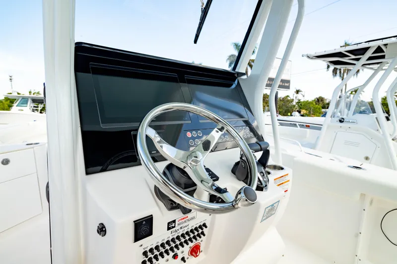 Slide: The Image of 2025 Edgewater 262CC boat dashboard with steering wheel and control panel. - 42