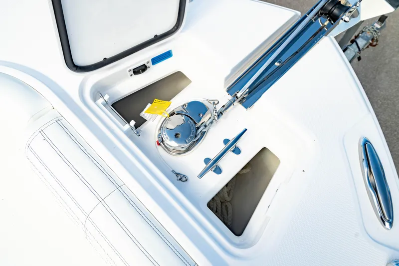 Slide: The Image of Edgewater 262CC 2025 boat anchor compartment with winch and storage spaces. - 49