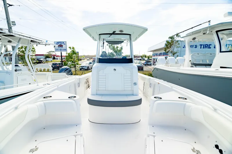 Slide: The Image of 2025 Edgewater 262CC boat interior with seating and console, displayed at a dealership. - 9