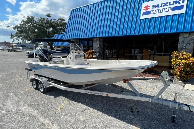 Slide: The Image of 2025 Carolina Skiff 21 LS boat on trailer outside Suzuki Marine dealership. - 4