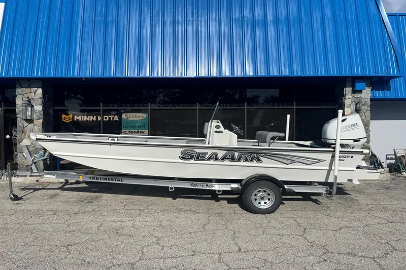 Slide: The Image of 2023 SeaArk 2072 FXTD CC boat on trailer, parked outside a blue-roofed building. - 3