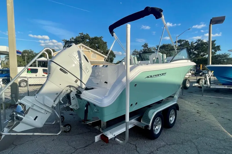Slide: The Image of 2024 Aquasport 2200 DC boat on trailer with Suzuki outboard motor. - 7
