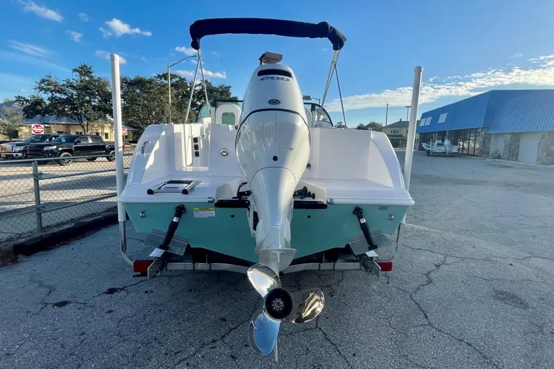 Slide: The Image of 2024 Aquasport 2200 DC boat, rear view with outboard motor, parked outdoors. - 8