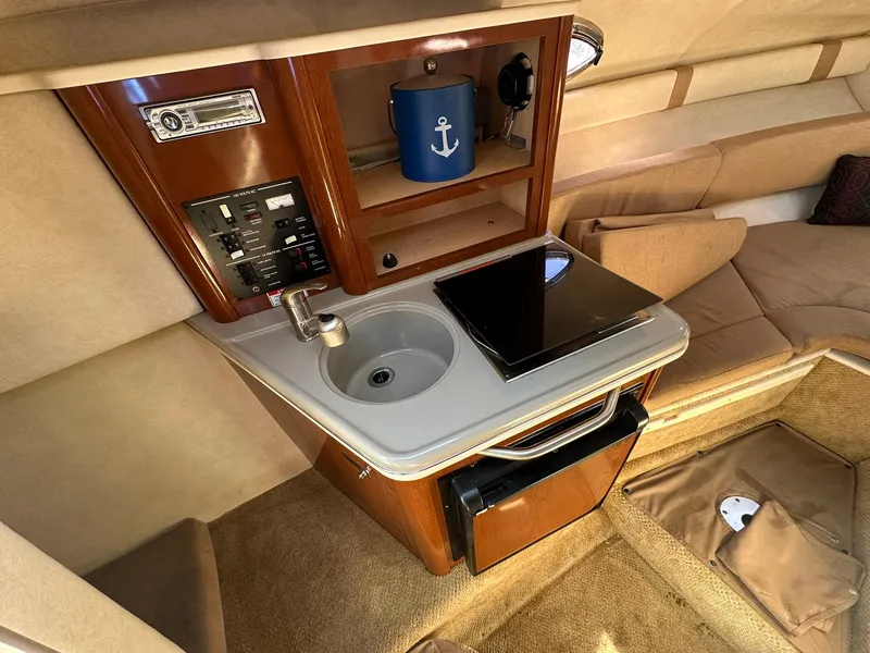 Slide: The Image of 2010 Sea Ray 240 Sundancer cabin interior with kitchenette and seating area. - 10