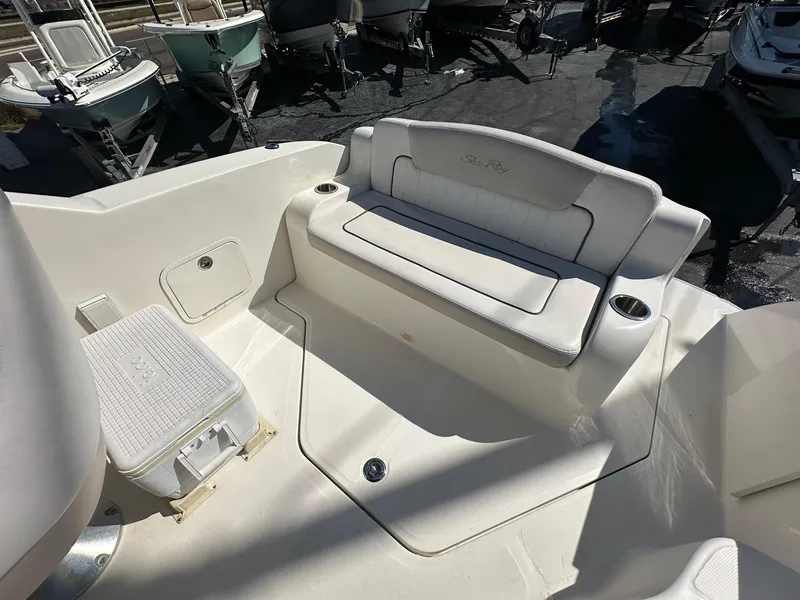 Slide: The Image of 2010 Sea Ray 240 Sundancer boat interior with white seating and storage area. - 18