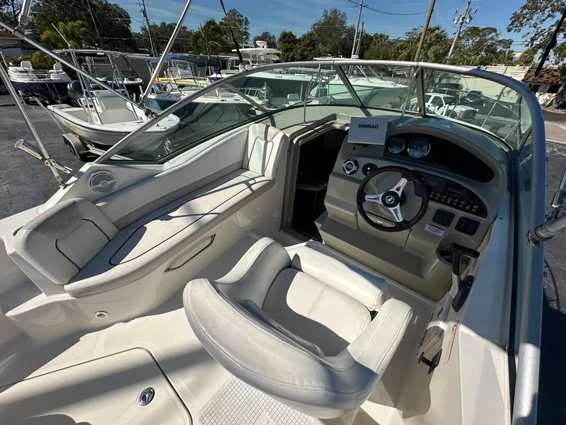 Slide: The Image of 2010 Sea Ray 240 Sundancer boat interior with steering wheel and seating area. - 20