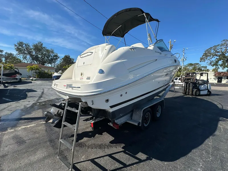 Slide: The Image of 2010 Sea Ray 240 Sundancer boat on trailer, parked outdoors under clear sky. - 4