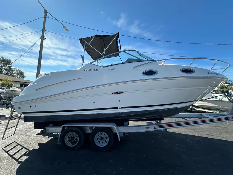 Slide: The Image of 2010 Sea Ray 240 Sundancer boat on trailer under clear blue sky. - 5