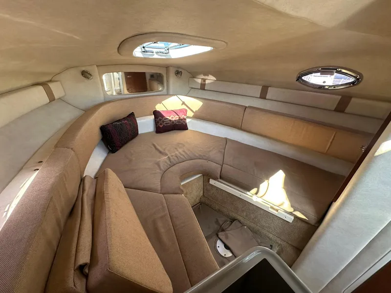 Slide: The Image of Interior cabin of 2010 Sea Ray 240 Sundancer with beige seating and cushions. - 9