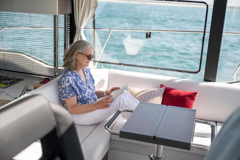 Slide: The Image of Woman reading on Jeanneau NC 1295 Coupe yacht, 2025 model, with ocean view. - 16