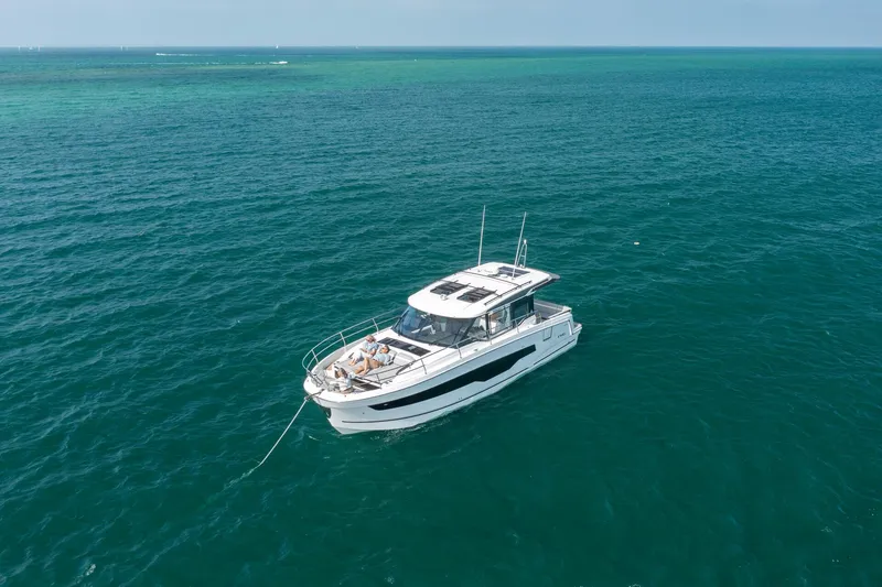 Slide: The Image of 2025 Jeanneau NC 1295 Coupe yacht cruising on open sea. - 5