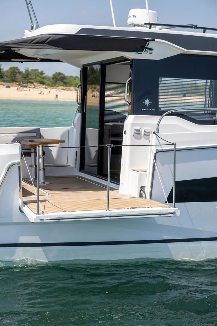 Slide: The Image of 2025 Jeanneau NC 1295 Coupe yacht on water, featuring sleek design and spacious deck. - 7
