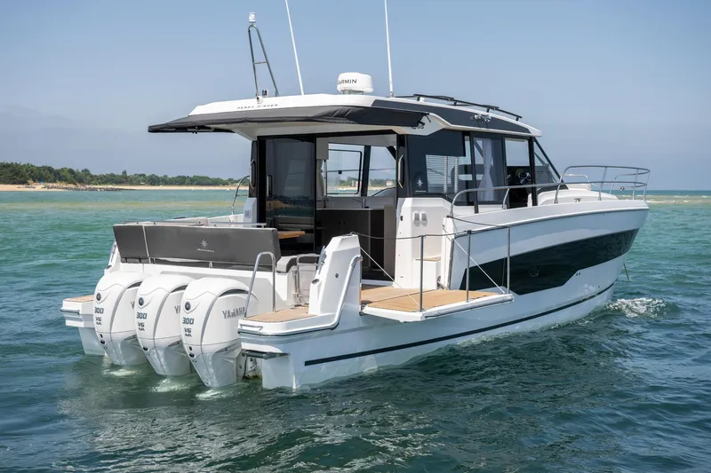 Slide: The Image of 2025 Jeanneau NC 1295 Coupe boat on water, featuring triple Yamaha engines. - 9