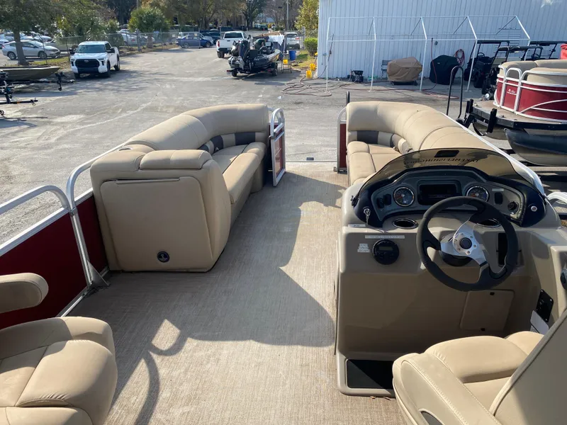 Slide: The Image of 2020 Sun Tracker Party Barge 24 DLX interior with beige seating and steering console. - 4