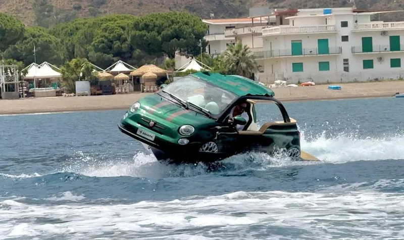 Slide: The Image of 2025 Car Off-shore Fiat 500 Abarth driving on water near a coastal area. - 25