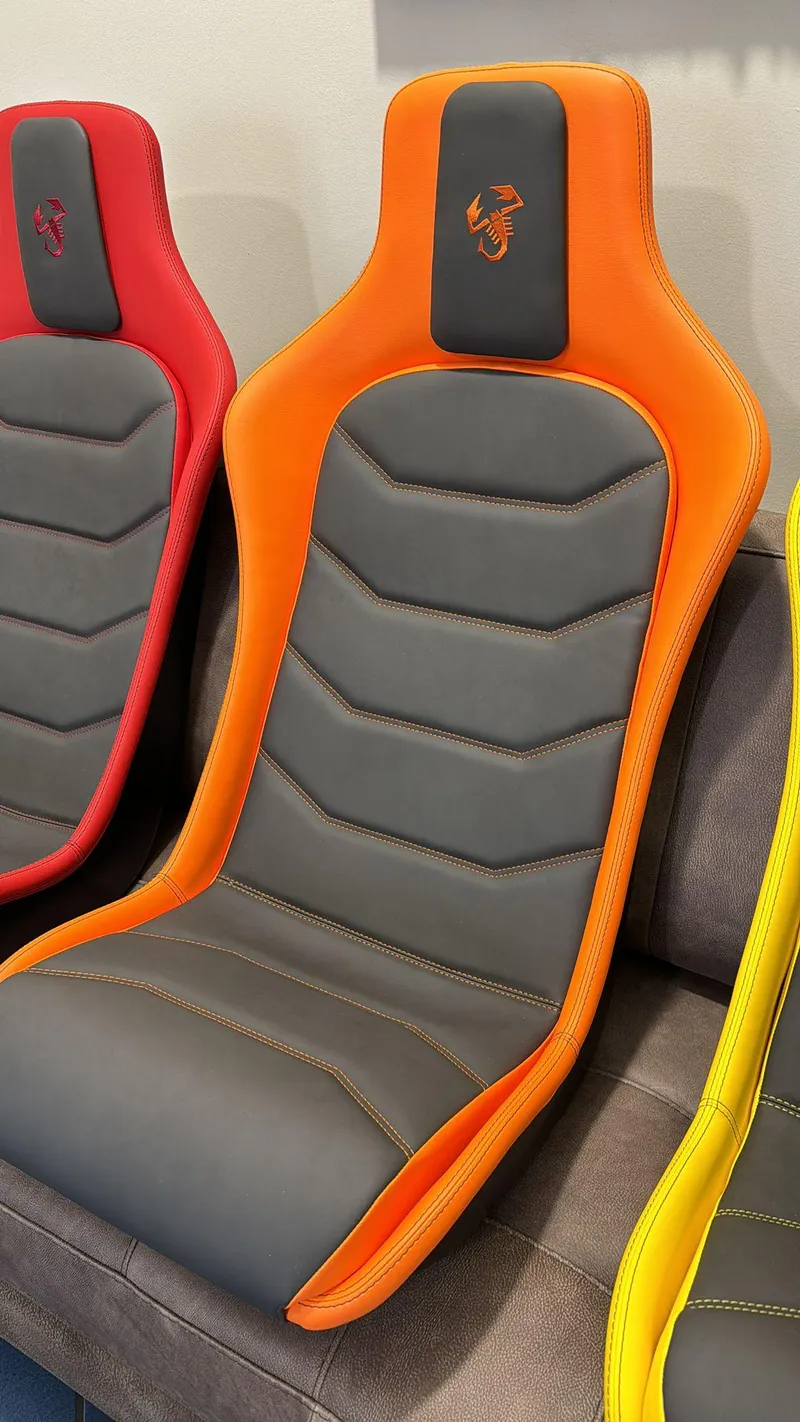 Slide: The Image of Orange and gray car seat for 2025 Fiat 500 Abarth, featuring sporty design. - 28
