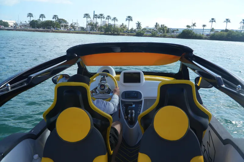 Slide: The Image of 2025 Car Off-shore Fiat 500 Abarth on water, featuring yellow seats and steering wheel. - 5
