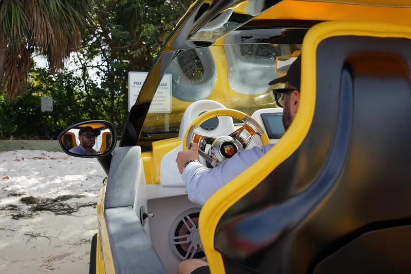 Slide: The Image of 2025 Car Off-shore Fiat 500 Abarth interior, yellow design, parked on sandy beach. - 6