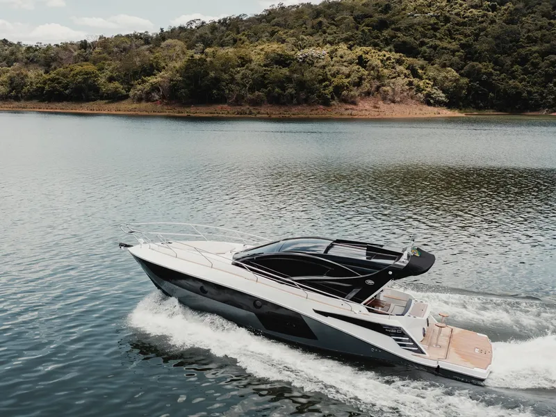 Slide: The Image of 2025 Granfort 420 Gran Coupe cruising on a serene lake with lush forest backdrop. - 2
