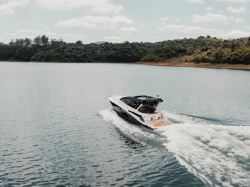 Slide: The Image of 2025 Granfort 420 Gran Coupe cruising on a serene lake with lush green surroundings. - 3