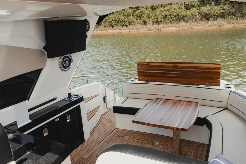 Slide: The Image of 2025 Granfort 420 Gran Coupe yacht interior with elegant seating and wooden table by the water. - 5