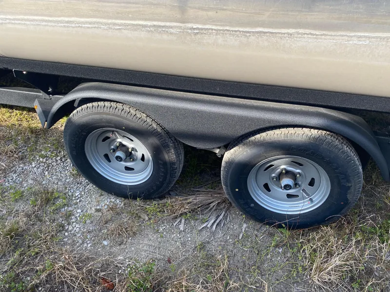 Slide: The Image of Trailer wheels of 2020 Sun Tracker Party Barge 24 DLX on grass. - 6