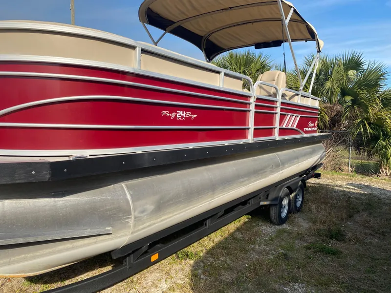 Slide: The Image of 2020 Sun Tracker Party Barge 24 DLX pontoon boat with red exterior and canopy. - 7