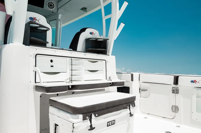 Slide: The Image of 2024 Crevalle 33 CTF boat interior with seating and storage against a clear blue sky. - 18