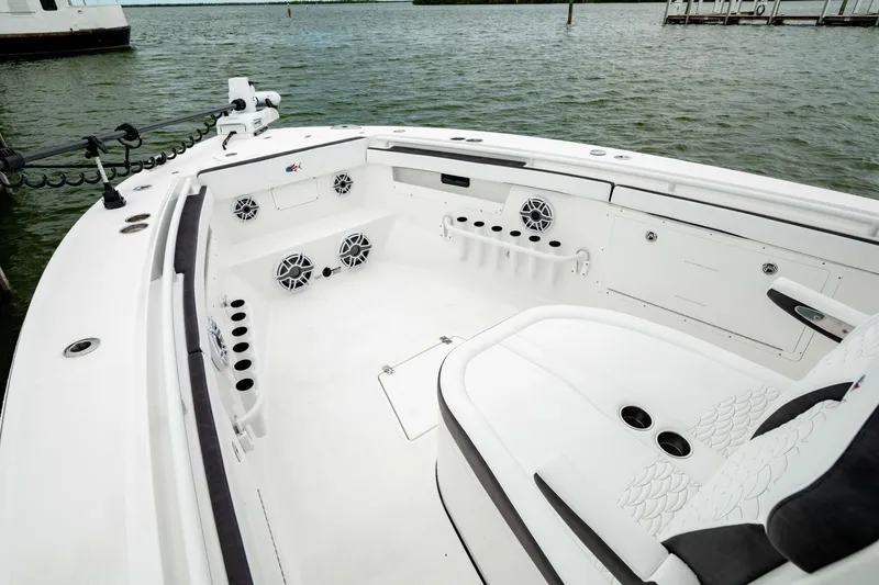 Slide: The Image of 2024 Crevalle 33 CTF boat interior with seating and rod holders, on calm water. - 3