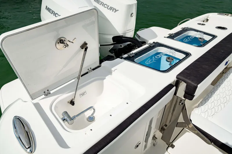Slide: The Image of 2024 Crevalle 33 CTF boat with open storage compartments and Mercury engines. - 9