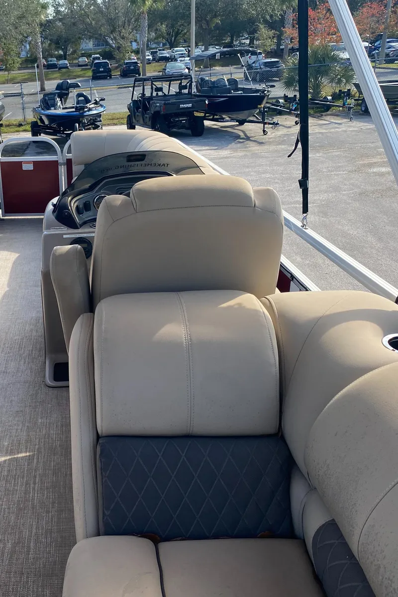 Slide: The Image of 2020 Sun Tracker Party Barge 24 DLX with beige seating, parked outdoors. - 5