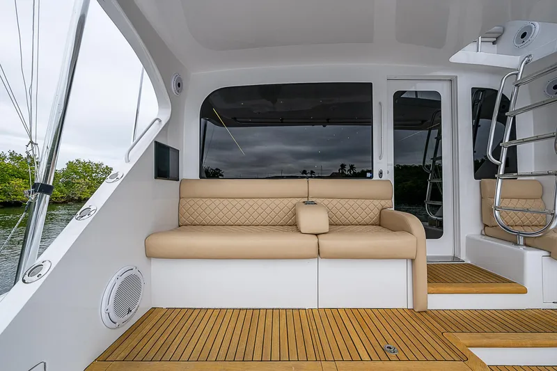 Slide: The Image of 2008 Hatteras 60 GT yacht interior with beige seating and wooden flooring. - 13
