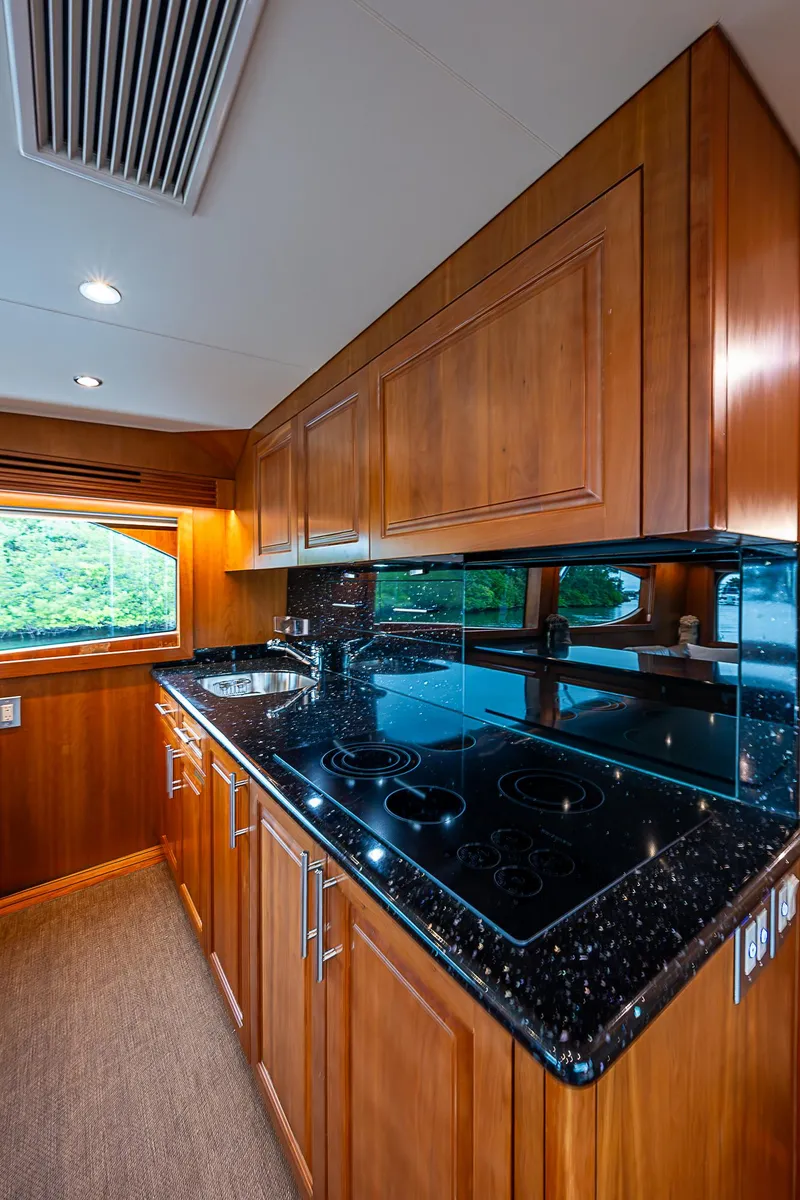 Slide: The Image of Luxurious kitchen interior of 2008 Hatteras 60 GT yacht with wooden cabinetry and modern appliances. - 22