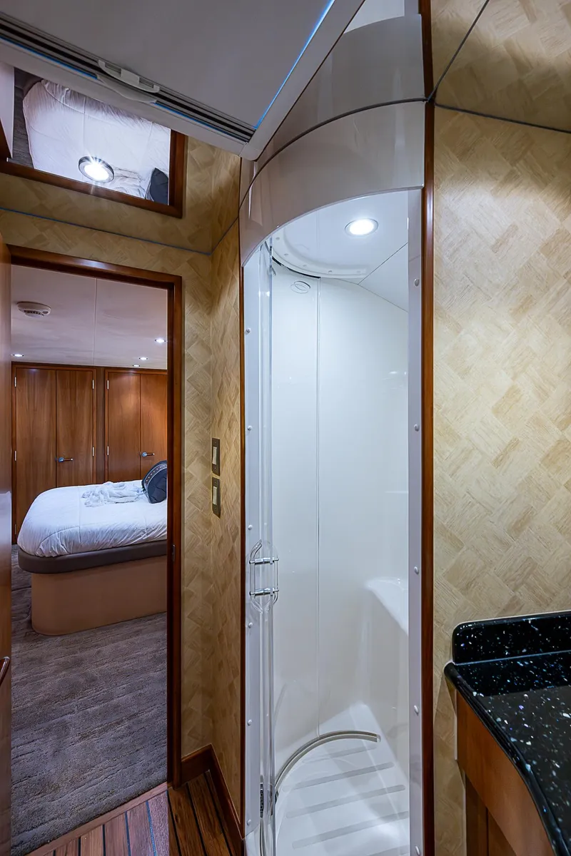 Slide: The Image of Interior of 2008 Hatteras 60 GT yacht, featuring a modern shower and cozy bedroom. - 29