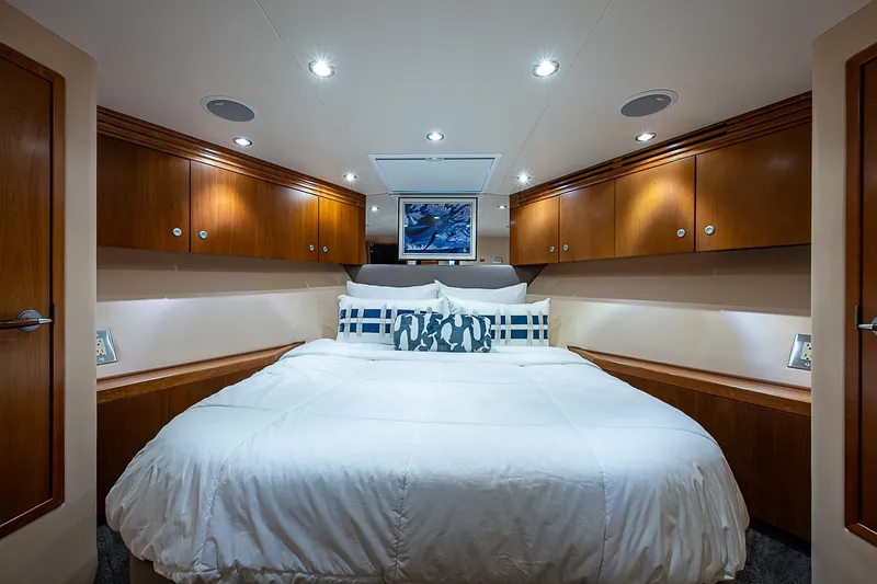 Slide: The Image of Luxurious bedroom interior of 2008 Hatteras 60 GT yacht with wood cabinets and cozy bedding. - 30
