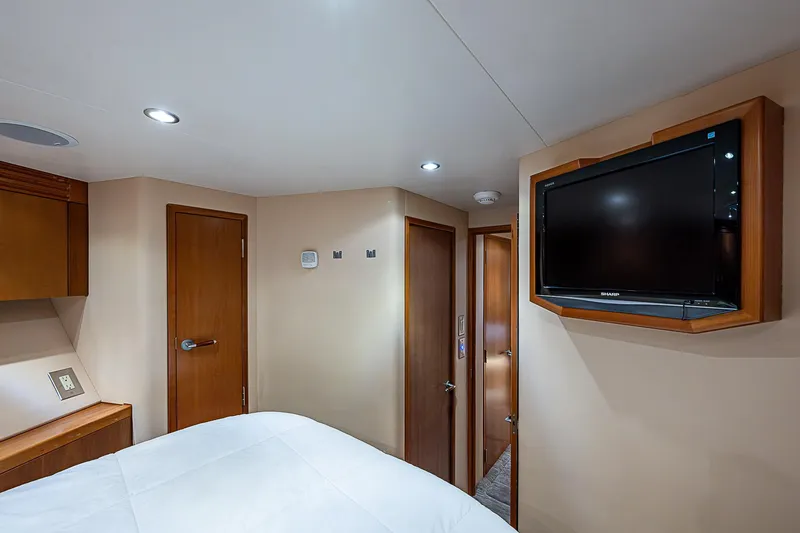 Slide: The Image of Interior of 2008 Hatteras 60 GT yacht bedroom with TV and wooden doors. - 31
