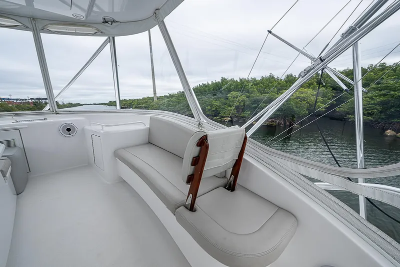 Slide: The Image of 2008 Hatteras 60 GT yacht interior with white seating, overlooking water and greenery. - 42